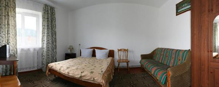 Cozy bedroom with bed sofa and bright window curtains