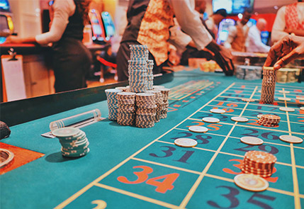 Casino roulette table with poker chips and dealers in action