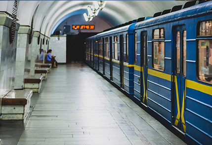A blue metro train arriving at an underground station platform